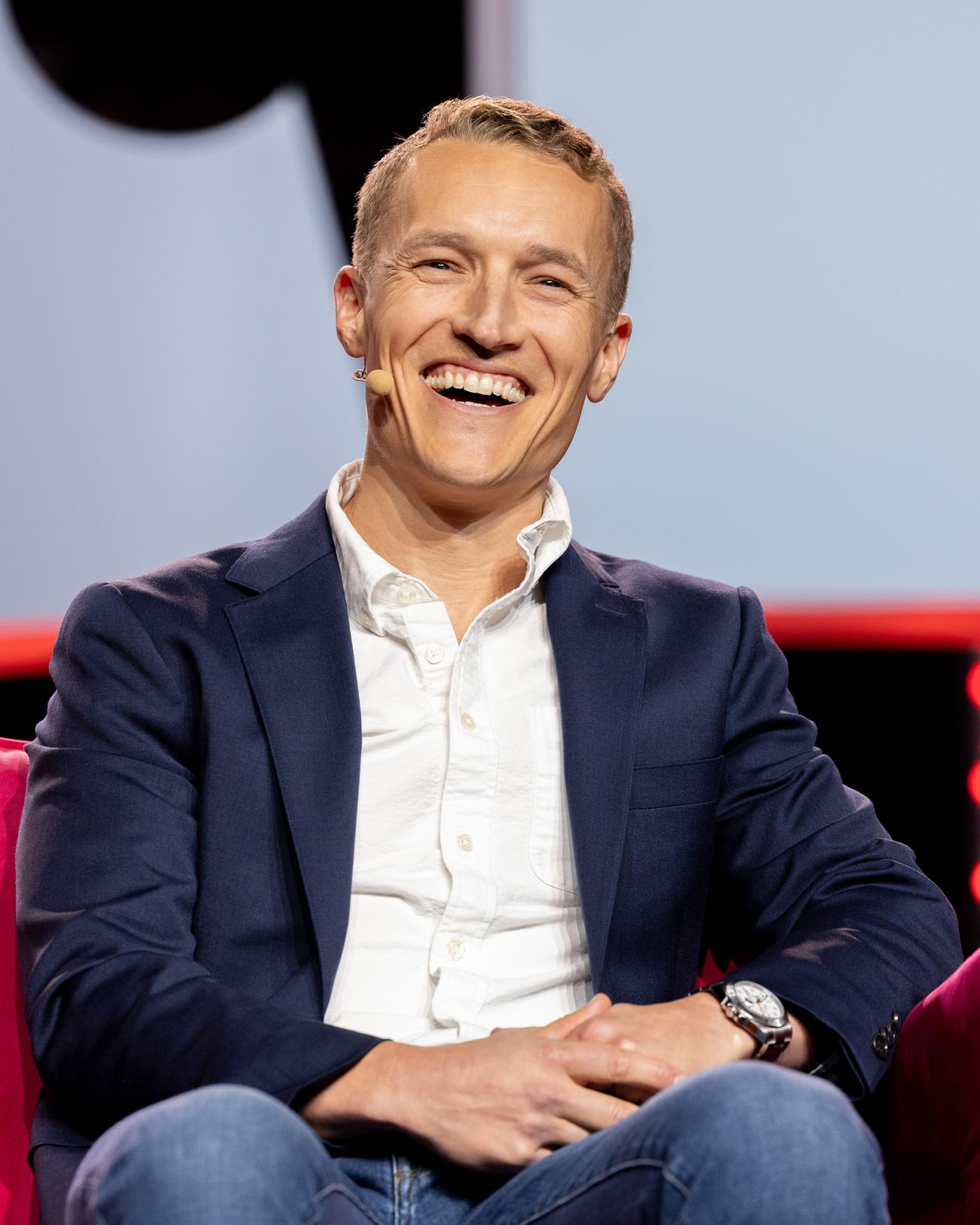 Speaker laughing during an HLTH session
