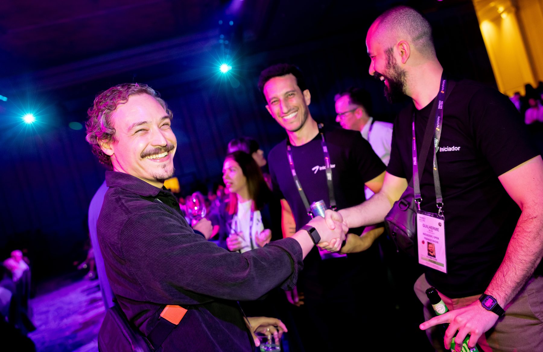 Attendees laughing and shaking hands at a Money20/20 evening reception