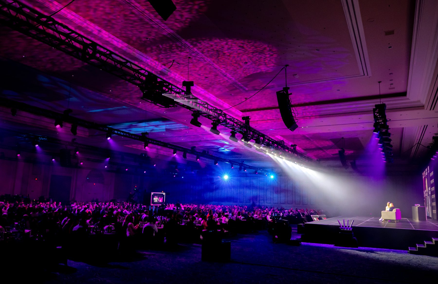 The Money20/20 main stage ballroom at full capacity under pink and blue truss lighting