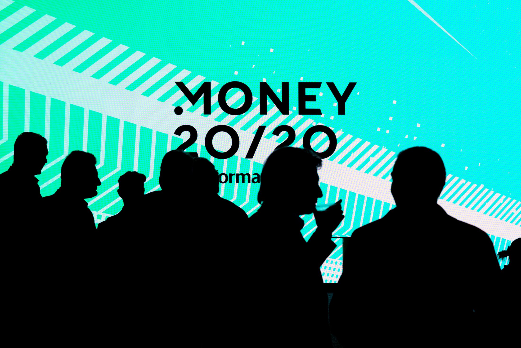 Attendees silhouetted against a giant teal Money20/20 logo wall at Money20/20 USA 2025